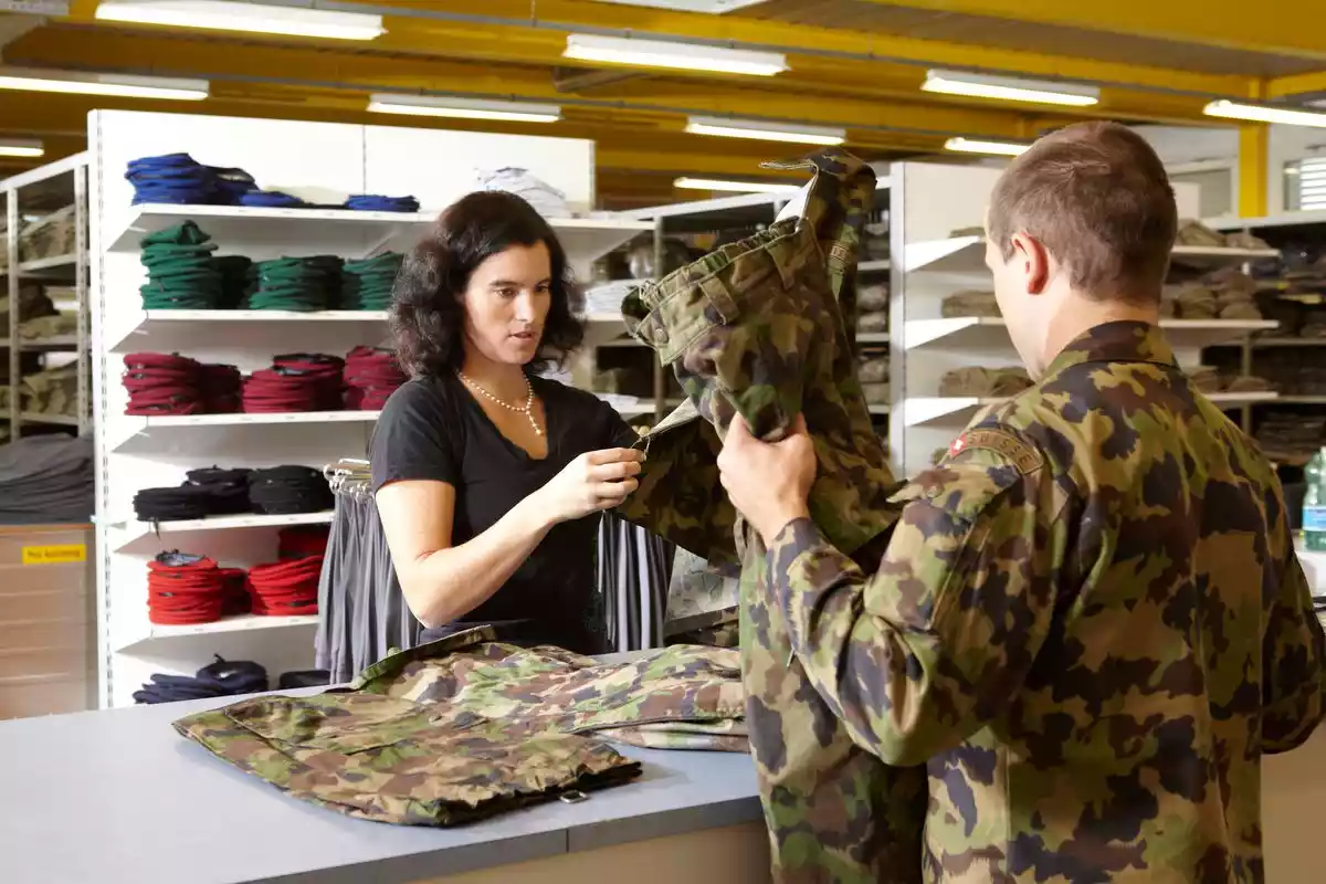 Collaboratrice du centre logistique à la remise des habits Un militaire reçoit sa tenue de camouflage 90 (T cam 90) CC BY-NC-ND
